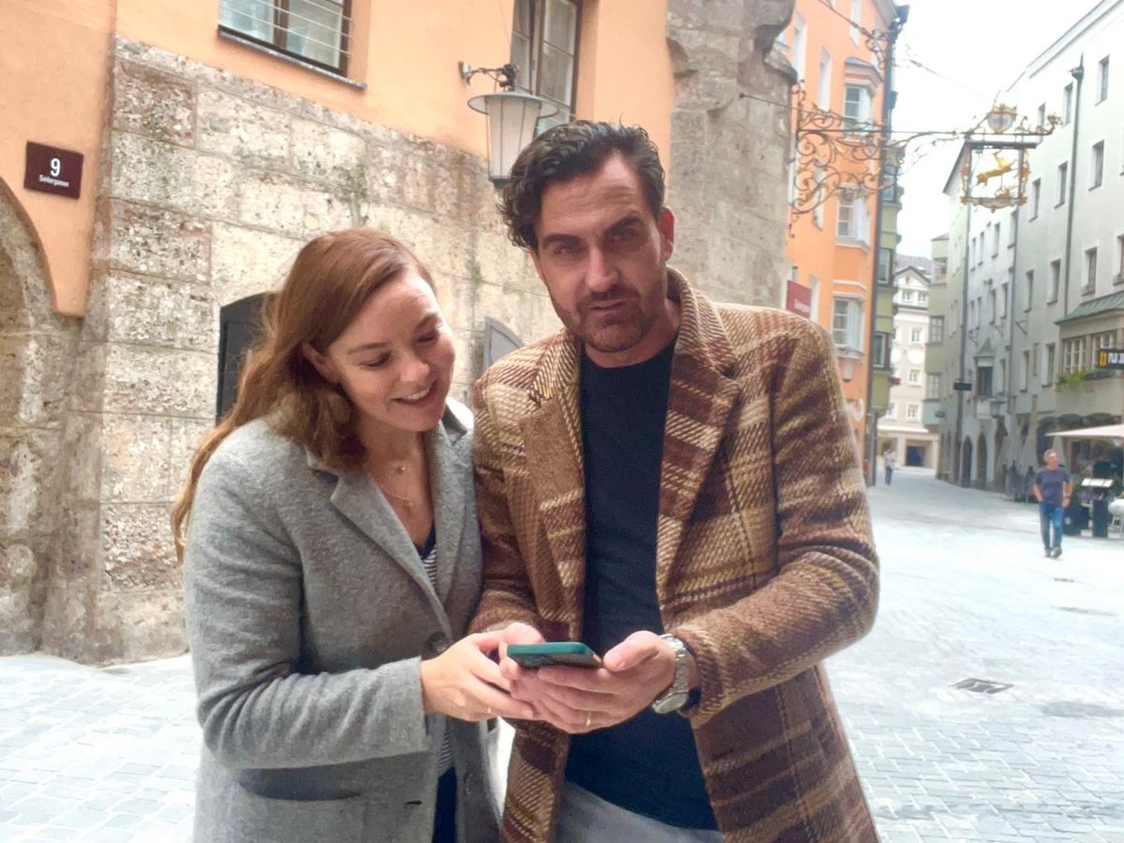 Zwei Menschen entdecken gemeinsam mit dem Smartphone die Innsbrucker Altstadt